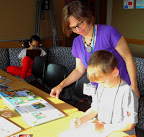 Children's coordinator Beth Troop helps one of the children with an activity.